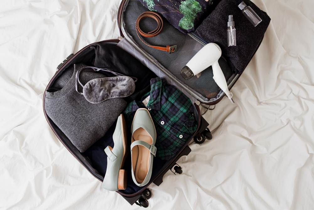 Luggage,With,Stylish,Female,Clothes,On,White,Messy,Bed,Sheet